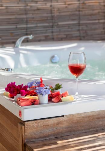 a plate of food and a glass of wine on a bath tub at Vega Aparts in Gümüşlük