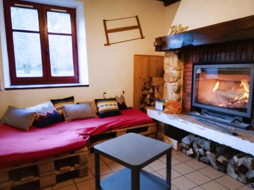 a living room with two benches in front of a fireplace at Les chalets de la forêt d'Issaux in Osse-en-Aspe