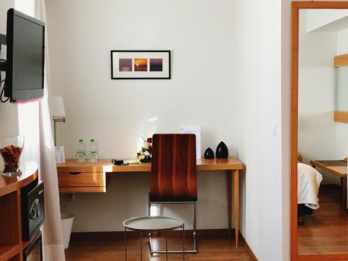 a room with a desk with a chair and a tv at Le Pietri Urban Hotel in Rabat