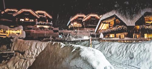a snow covered ski slope in front of a building at Mountain Loft in Tarvisio