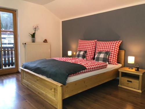 um quarto com uma cama com almofadas vermelhas e brancas em Ferienhaus am Hocheck em Oberaudorf