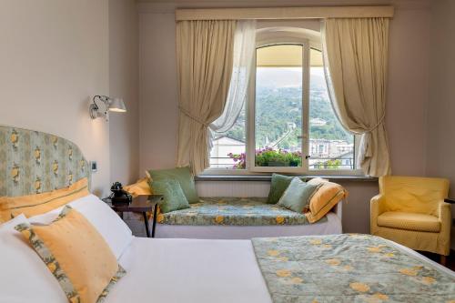 Habitación de hotel con 2 camas y ventana en Bijou Hotel en Saint Vincent