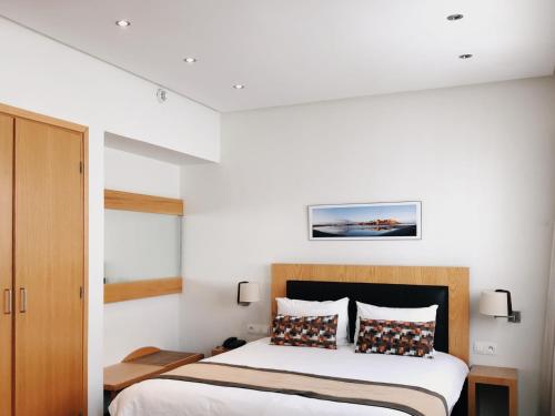 a bedroom with a bed with white walls at Le Pietri Urban Hotel in Rabat