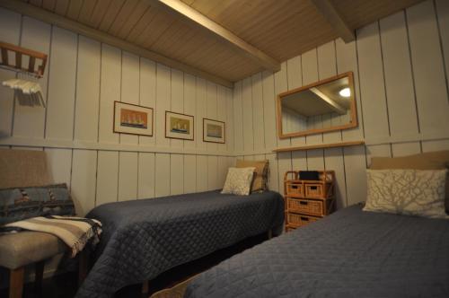a bedroom with two beds and a chair in it at Villa Vimpasaari in Hamina