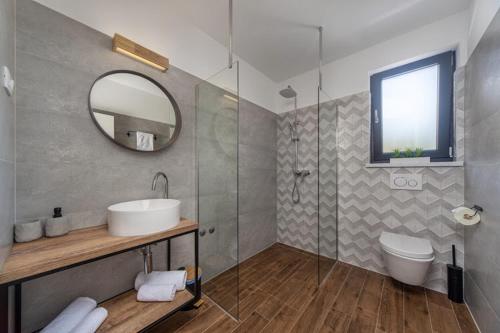 uma casa de banho com um lavatório e um espelho em Villa Askim Prestige em Opatija