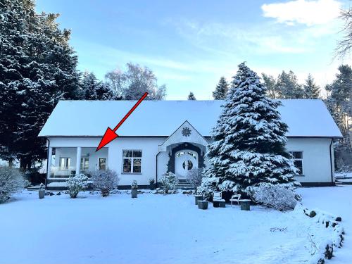 a house with a clock on the roof in the snow at The Retreat Tranquil Countryside Apartment in Larkhall