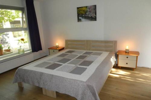 een slaapkamer met een bed met 2 tafels en 2 kaarsen bij Huis bij de Catalpa in Dordrecht
