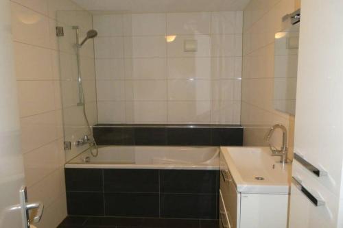 a bathroom with a bath tub and a sink at Huis bij de Catalpa in Dordrecht