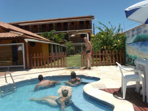 three people in a swimming pool with a teddy bear at Pousada Paradise in Alcobaça