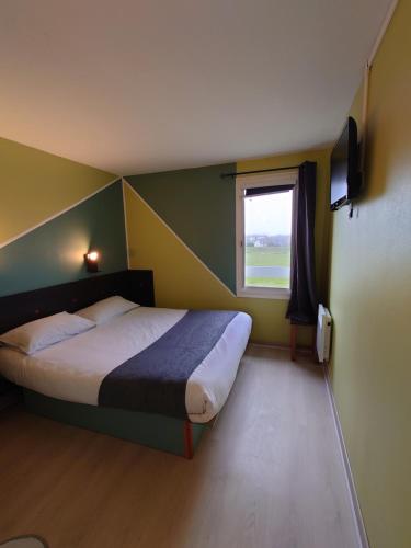 a small bedroom with a bed and a window at Fasthotel Angers Beaucouz&eacute; in Beaucouz&eacute;