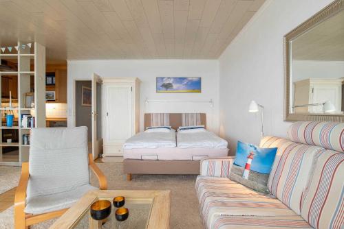 ein Wohnzimmer mit einer Couch und einem Bett in der Unterkunft Ferienwohnung Seeblick in Schilksee