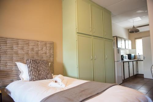a bedroom with green cabinets and a bed at Melrose Place Guestrooms in Potchefstroom