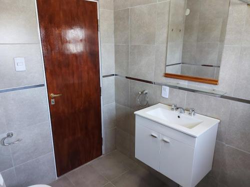 baño con lavabo y puerta de madera en Terra Vista en Huerta Grande