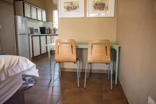 two chairs sitting at a table in a kitchen at Melrose Place Guestrooms in Potchefstroom