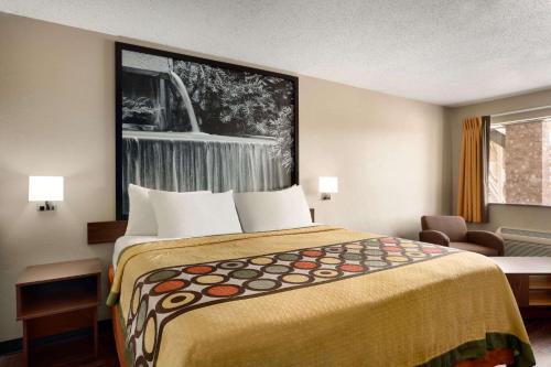 a hotel room with a bed and a chair at Super 8 by Wyndham Universal City in Universal City