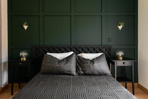 ein Schlafzimmer mit grünen Wänden und einem Bett mit Kissen in der Unterkunft Casa amigavel da Terra in Sesimbra