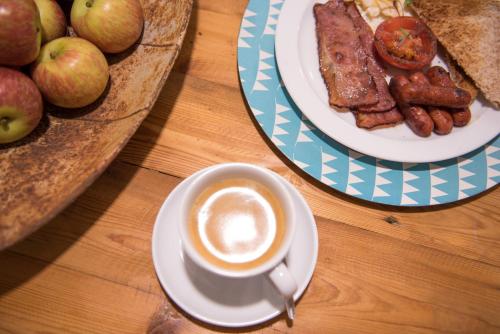 a table with a cup of coffee and a plate of food at Melrose Place Guestrooms in Potchefstroom