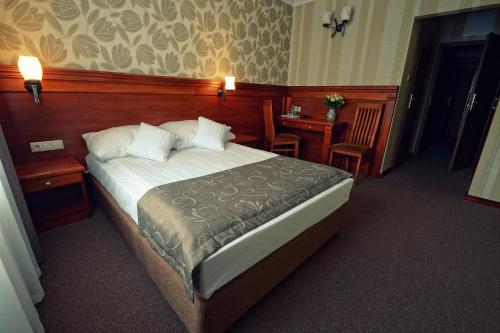 a bedroom with a large bed and a desk with a table at Hotel Jamajka in Wągrowiec