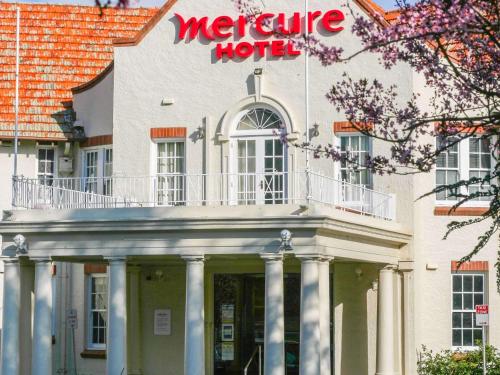 a large white building with a hotel sign on it at Mercure Canberra in Canberra