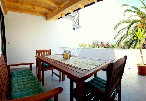 a dining room table and chairs on a patio at Apartmani Tina in Jelsa