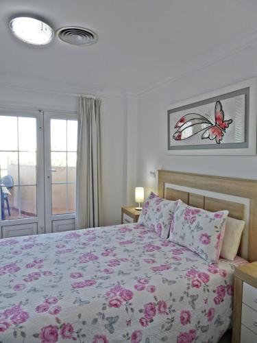 a bedroom with a bed with a butterfly on the wall at GOLF Y MAR - Oliva Nova in Oliva