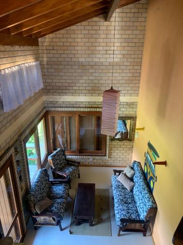 einen Blick über das Wohnzimmer mit Sofas und Stühlen in der Unterkunft Pousada e Hostel Vale do Rosa in Praia do Rosa