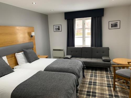 a hotel room with two beds and a couch at Crowwood Hotel and Alba Restaurant in Chryston