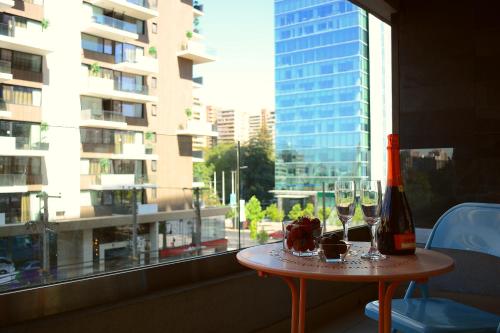サンティアゴにあるSunset Apartsのグラス2つとワイン1本が置かれたテーブル