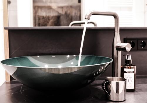 a bathroom sink with a glass bowl and a faucet at Die Waldruhe in Kartitsch