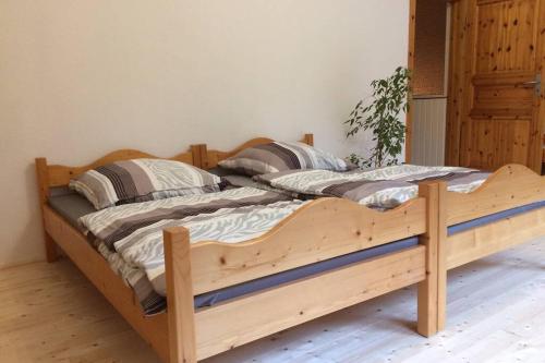 uma cama de madeira com duas almofadas num quarto em Große Ferienwohnung auf Pferdehof Mitten in der Natur 
