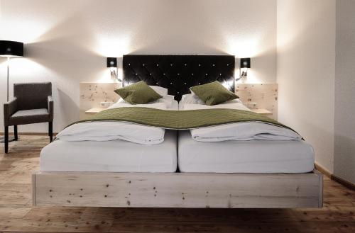 a bedroom with a large bed with a black headboard at Die Waldruhe in Kartitsch