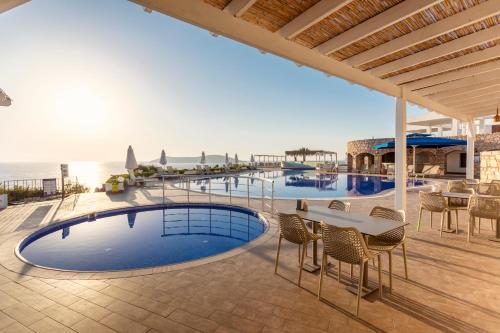 a resort with a pool and tables and chairs at Vega Aparts in Gümüşlük