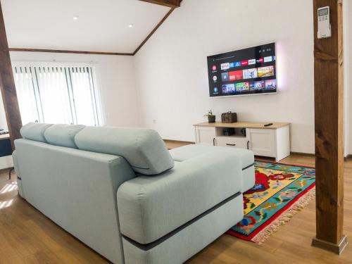 sala de estar con sofá y TV de pantalla plana en Stylish loft studio with great view to Ardino, en Ardino