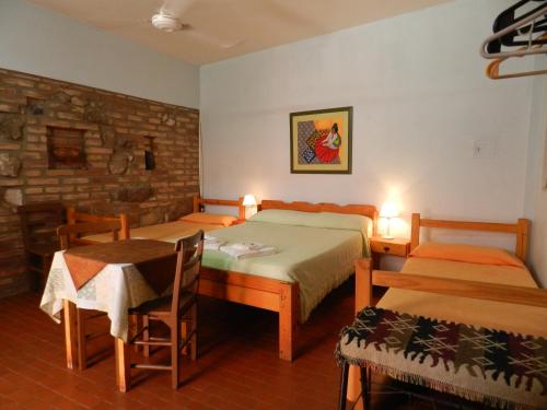 1 Schlafzimmer mit 2 Betten, einem Tisch und Stühlen in der Unterkunft Hostel Ctalamochita in Embalse