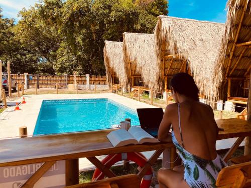 una mujer sentada en una mesa con un portátil junto a una piscina en Palomino Sunrise, en Palomino