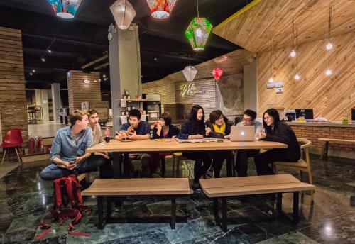 a large group of people sitting at a table at Meander Taipei Hostel - Ximending in Taipei