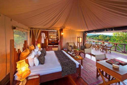 ein Schlafzimmer mit einem großen Bett in einem Zelt in der Unterkunft Neptune Mara Rianta Luxury Camp - All Inclusive. in Masai Mara