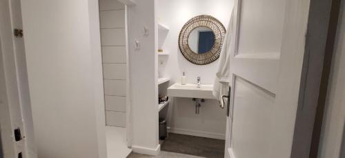 a white bathroom with a sink and a mirror at Kanne: charming house between nature and shopping in Kanne
