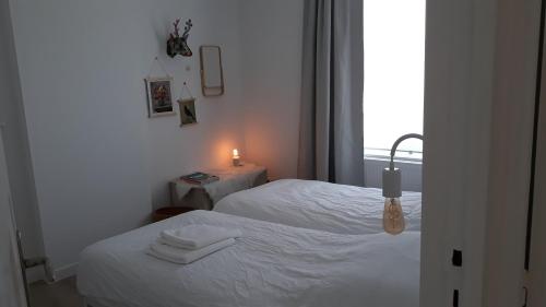 a bedroom with two beds and a candle on a table at Kanne: charming house between nature and shopping in Kanne