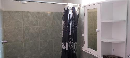 een douche met een zwart douchegordijn in de badkamer bij Mirador Yungaino in Yungay