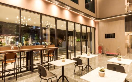 a restaurant with tables and chairs and large windows at Stanley Wahid Hasyim Jakarta in Jakarta