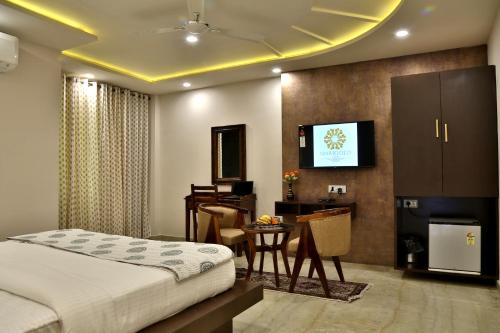 a bedroom with a bed and a desk and a television at Marigold Inn- Homestay in Jaipur