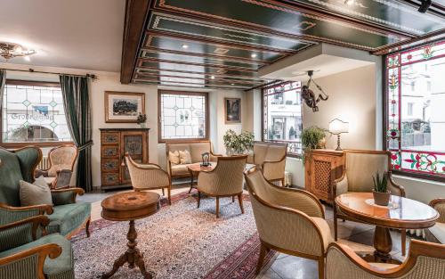 a waiting room with chairs and tables and windows at Hotel Cavallino D'Oro Bed&Breakfast in Castelrotto