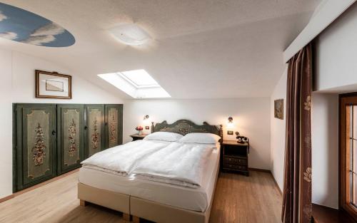 a bedroom with a large bed and a skylight at Hotel Cavallino D'Oro Bed&Breakfast in Castelrotto