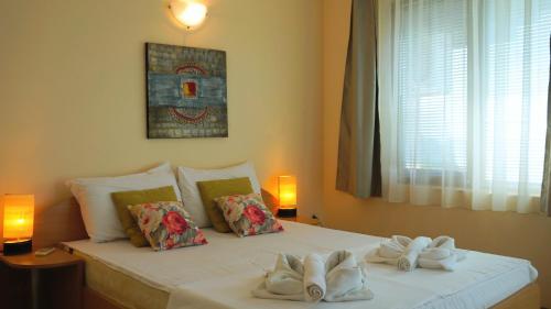 a bedroom with a bed with towels on it at Вила Помело - Family Villa Pomelo in Bŭlgarevo