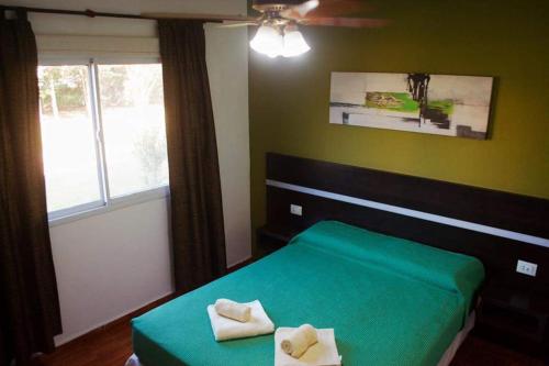 une chambre avec un lit vert et une fenêtre dans l'établissement Aparts serranos, à San Antonio de Arredondo