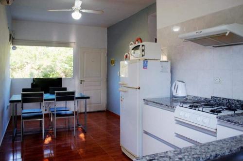 une cuisine avec un réfrigérateur blanc et une table dans l'établissement Aparts serranos, à San Antonio de Arredondo