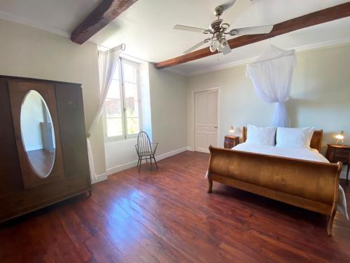 a bedroom with a bed and a ceiling fan at Maison de Haouret in Libaros