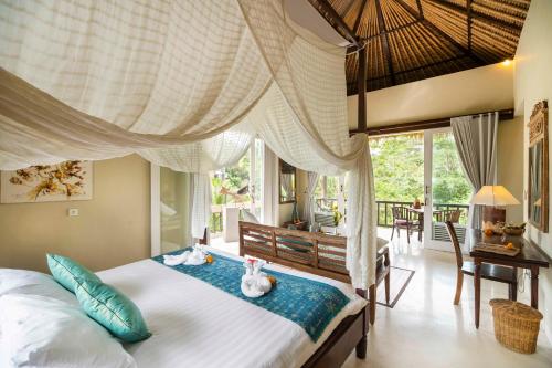 a bedroom with a bed with two stuffed animals on it at Surya Shanti Villa Sidemen in Sidemen