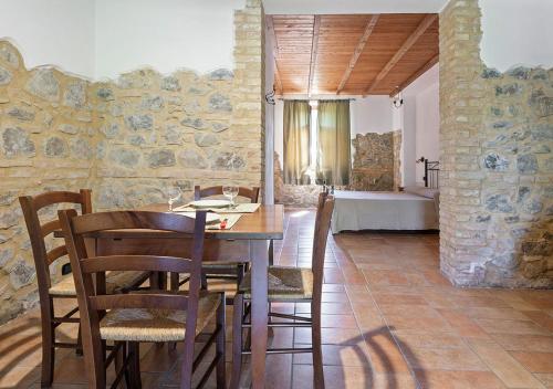 Agriturismo San Giuseppe في فولتيرا: غرفة طعام مع طاولة وكراسي وغرفة نوم